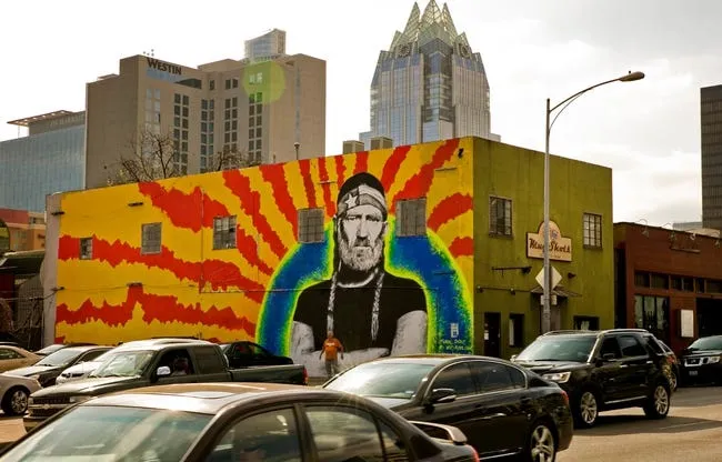 A 60-foot by 20-foot mural of Willie Nelson on a building housing the dive bar Mugshots looms over traffic on East Seventh Street in downtown Austin on February 22, 2016. Austin artist Wiley Ross painted the mural in 2016.