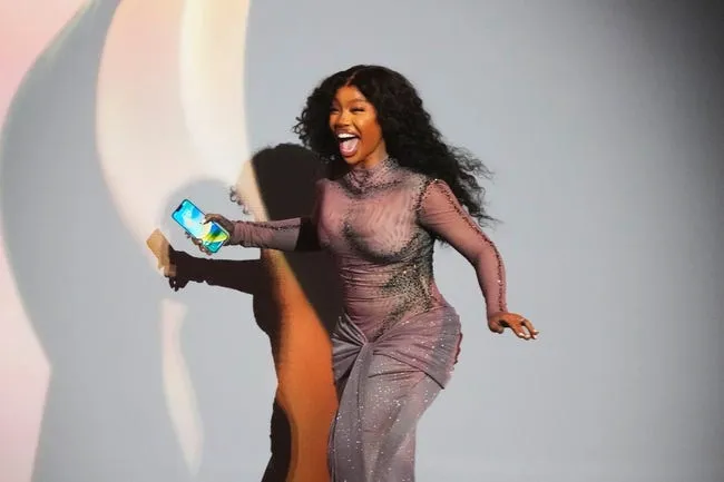 SZA runs to accept her Grammy award for best R&amp;B Song.