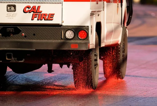 Fire retardant coats Mandeville Canyon Road on Jan 11, 2025, during a battle to save homes in the Brentwood community from the Palisades Fire that started on Jan. 7.