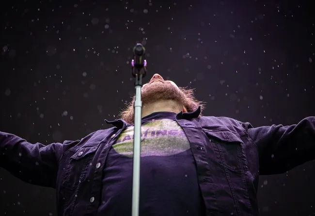 Lead singer Adam Duritz of Counting Crows looked up in the rain while singing 'Rain King' during their performance at the 2024 Railbird Festival at The Infield at Red Mile in Lexington, KY. June 1, 2024