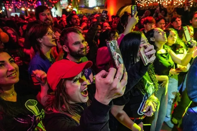 Nalliene Velez records Puerto Rican artist Bad Bunny’s performance with two phones, while yelling out in joy, during the Bad Bunny Super Bowl watch party at Tulum Detroit inside Taqueria El Rey in the heart of Mexican Town in Detroit, Sunday, Feb. 8, 2026.